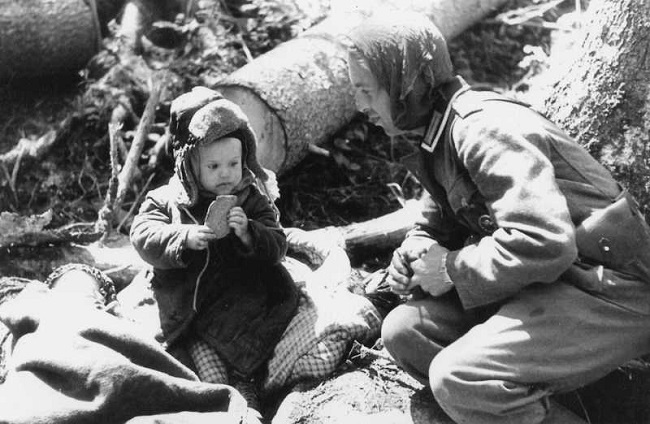 German soldier offering bread to russian boy