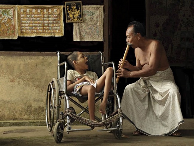 Man entertaining disabled child