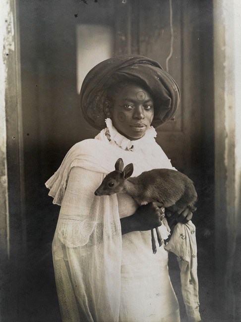 young Kenyan holding her pet deer