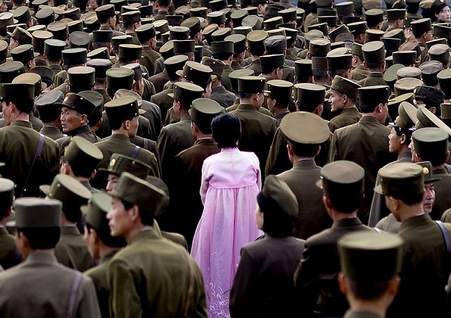 woman standing amidst the crowd of soldiers