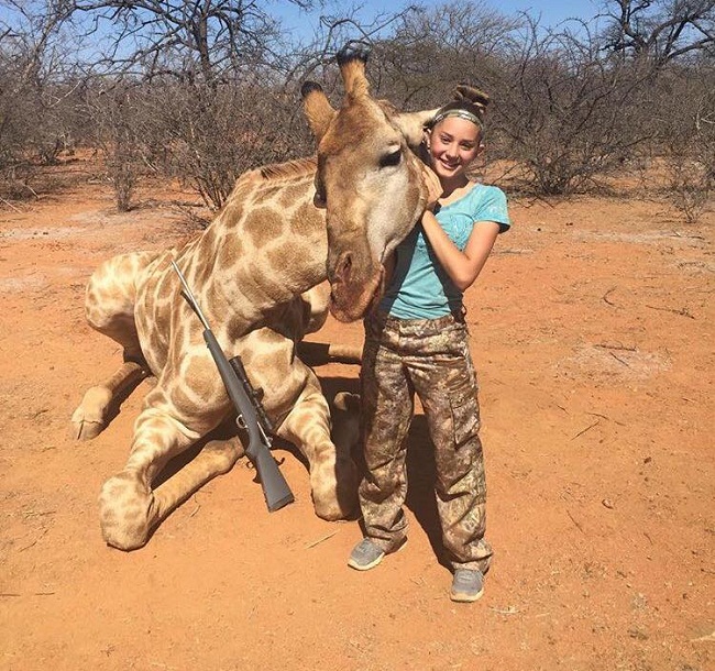 Aryanna Gourdin posing with dead giraffe