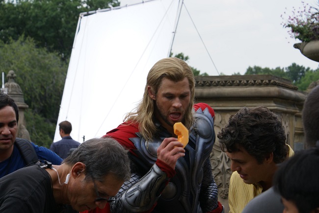 Chris Hemsworth eating a fruit on the set