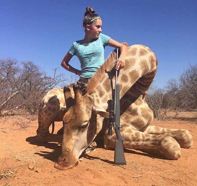 girl posing with dead giraffe 