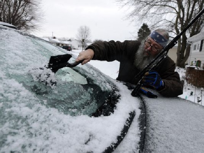 old man cleaning car windshield 