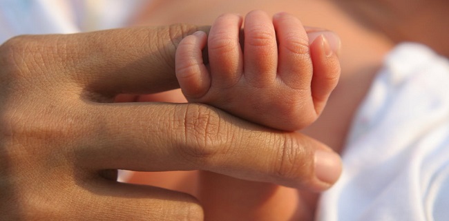 New born holding finger